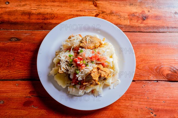 Top view of traditional Chancho dish with Yuca. Nicaraguan pork with yucca served on wooden table