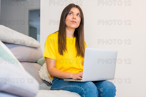 Woman with a computer sitting on a sofa