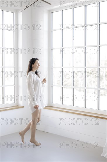 Attractive woman in a white shirt in front of a window