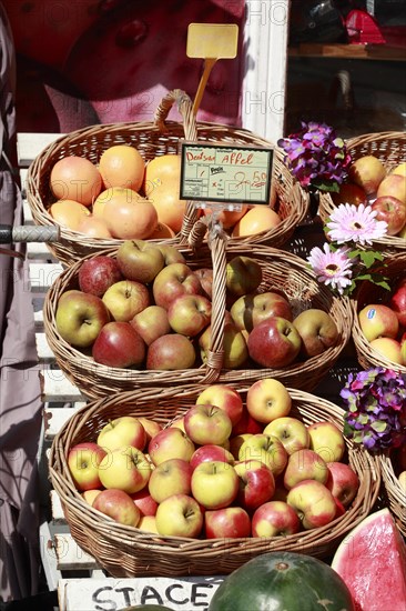 Apples with price tag in baskets on a stall in front of a shop