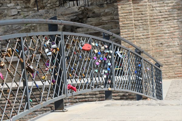 Many colorful metal love padlocks on fence