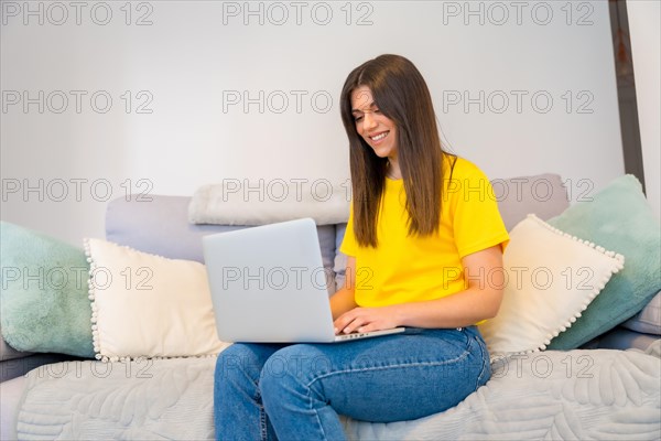 Portrait of woman with a computer sitting on a sofa