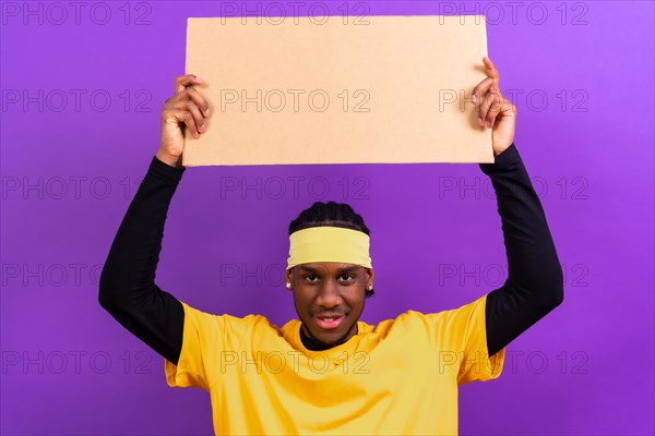 Black ethnic man in yellow clothes on a purple background