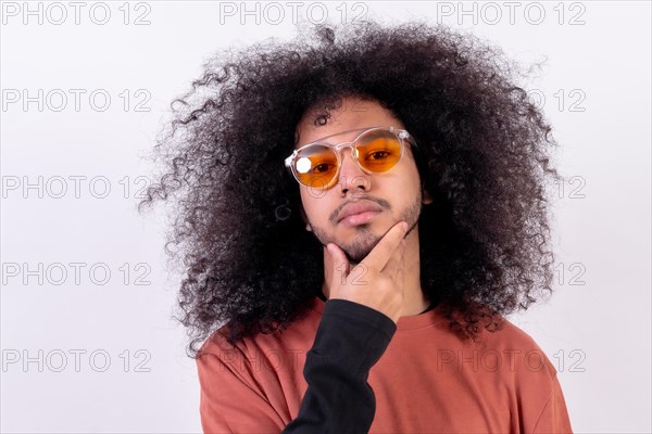 Portrait in sunglasses with seductive look. Young man with afro hair on white background