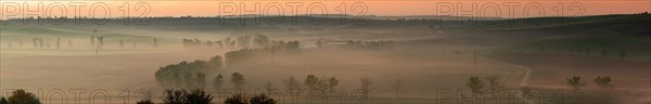 A wonderful large panorama of green Moravian fields shrouded in morning fog. Czech republic