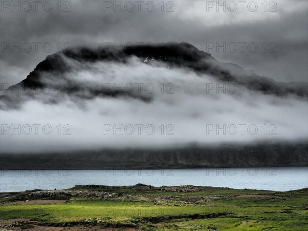 Fog drifts over mountainside