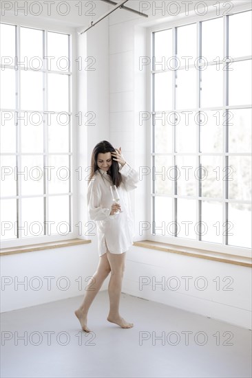 Attractive woman in a white shirt in front of a window