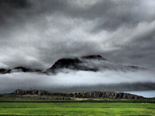 Fog drifts over mountainside