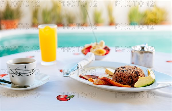 Morning breakfast on the table near a swimming pool. Close-up of a traditional breakfast on a table with a swimming pool in the background