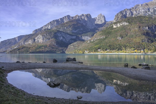 Mountains of the Brenta Group reflected in a small lagoon of Lake Molveno