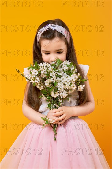 Cute little child sniffing the bouquet of spring flowers