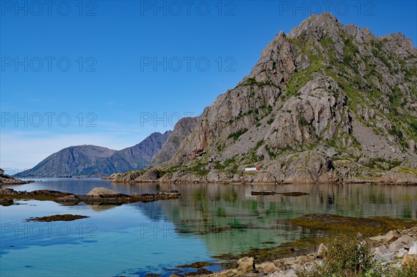 Shallow bay with crystal clear water in front of high mountain
