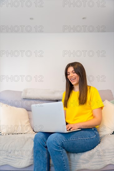 Portrait of woman with a computer sitting on a sofa