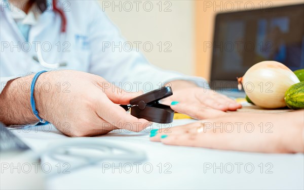 Hand of nutritionist using oximeter on finger of female patient. Close up of hands of nutritionist using pulse oximeter on patient finger. Nutritionist measuring oxygen pulse to patient