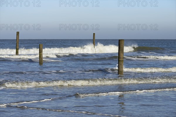 Leaking waves on the North Beach with boundary piles