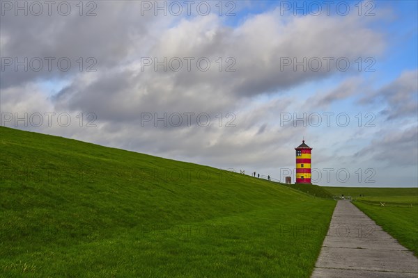 Pilsum lighthouse on the dyke near Greetsiel in the Krummhoern region on the East Frisian North Sea coast