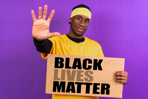 Black ethnic man in yellow clothes on a purple background