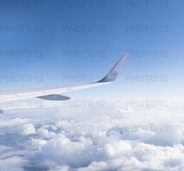 View of the wing of a Lufthansa aircraft over a sea of clouds