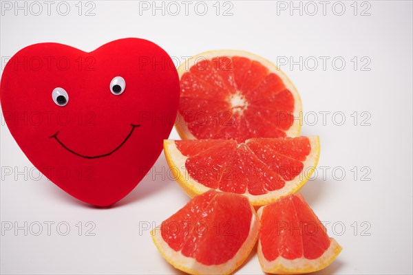 Smiling heart with a cut grapefruit healthy food concept