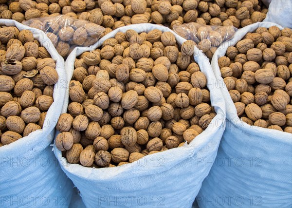 Sack of whole fresh walnuts with hard nutshells