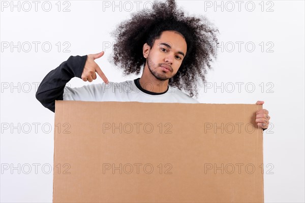 Pointing to a sign with copy paste space. Young man with afro hair on white background