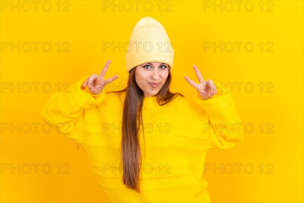 Young woman isolated on yellow background smiling and showing victory sign