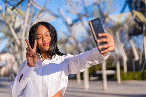Young african woman in white clothes in the city at sunset
