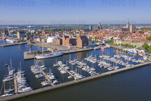 Marina and three-mast barque Gorch Fock docked in the harbour of the city Stralsund along the Strelasund in summer