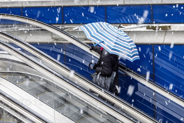 Passers-by with umbrella from the underground into the snowstorm