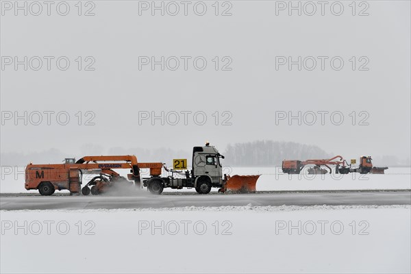 Road sweepers and snow ploughs clear snow on the taxiways and Runway North