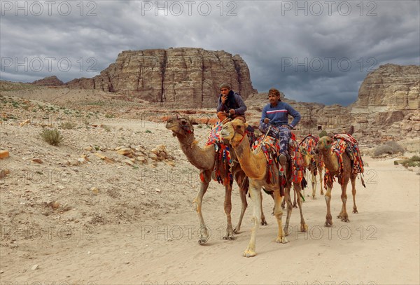 Bedouins with camels on horseback