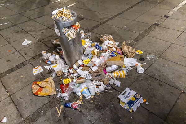 Full waste bins with packaging waste and cigarette butts