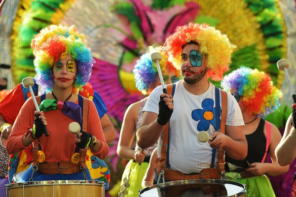 Multicoloured people of all ages praise the parade in Carnival