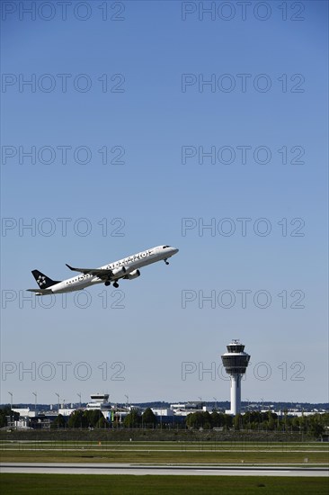 Taking off Star Alliance AIR DOLOMITI EMBRAER ERJ-195 on runway south with tower