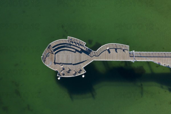 Aerial view over wooden fish-shaped pleasure pier at seaside resort Niendorf along the Baltic Sea
