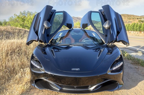 A black McLaren 720S with doors up