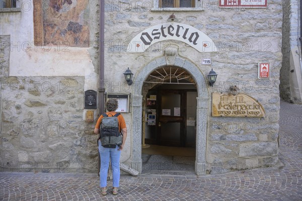 Woman studying menu in front of Osteria Catenaccio