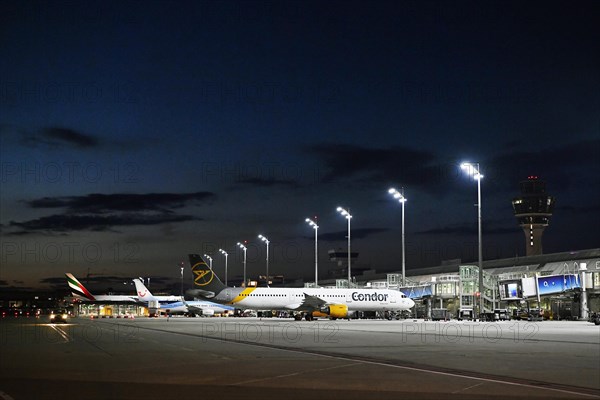 Terminal 1 at night with tower and Condor and TUI fly