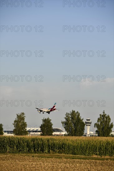 Eurowings Airbus A320 landing on Runway North with Tower Munich Airport and cornfield in the foreground