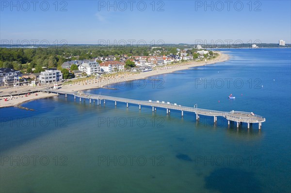 Aerial view over wooden pleasure pier and hotels at seaside resort Niendorf along the Baltic Sea