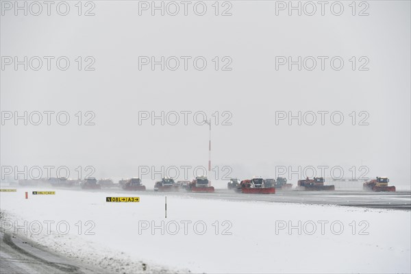 Road sweepers and snow ploughs clear snow on the taxiways and Runway North