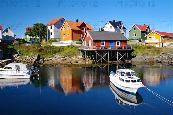 Different coloured hozhouses reflected in crystal clear sea water