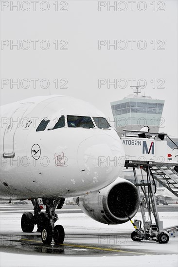 Lufthansa Airbus A319-100 in winter with snow with passenger boarding bridge