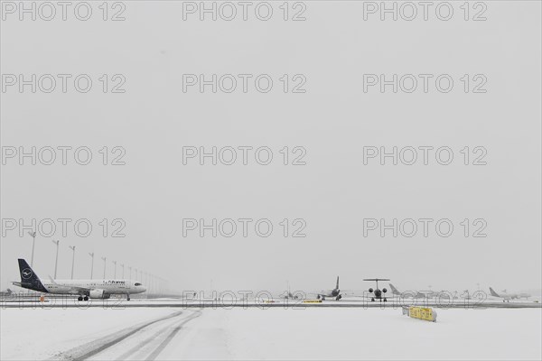 Aircraft in wait for de-icing and take-off clearance in winter snow flurry