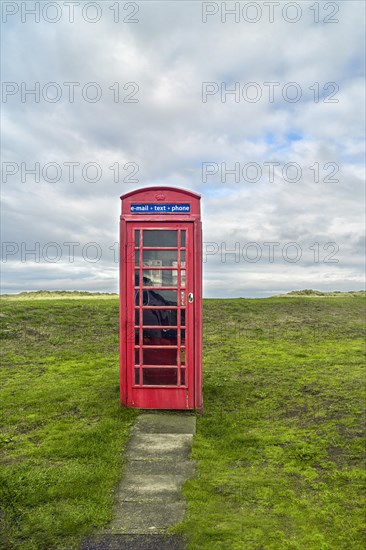 Red telephone box in meadow