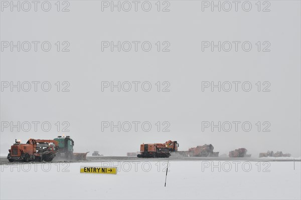 Road sweepers and snow ploughs clear snow on the taxiways and Runway North