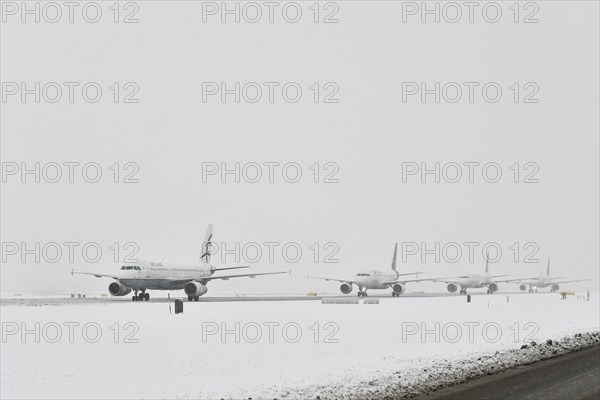 Aircraft taxiing on taxiway in winter snow flurry for take-off clearance
