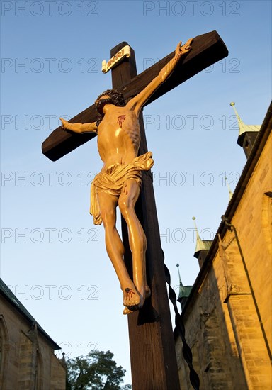 Jesus Christ on the cross between Erfurt Cathedral and Severi Church in early morning light