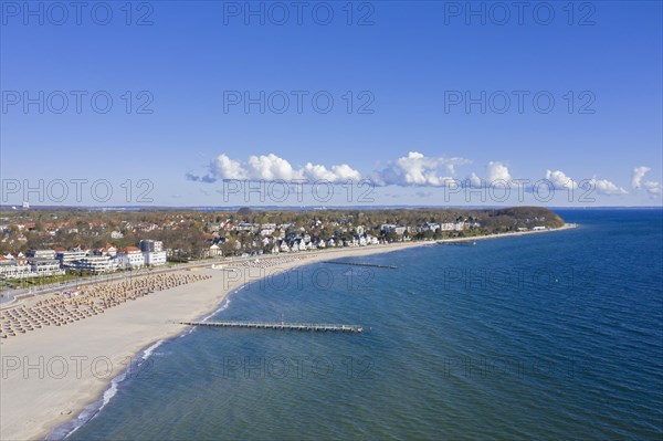 Aerial view over sandy beach with roofed wicker beach chairs at seaside resort Travemuende