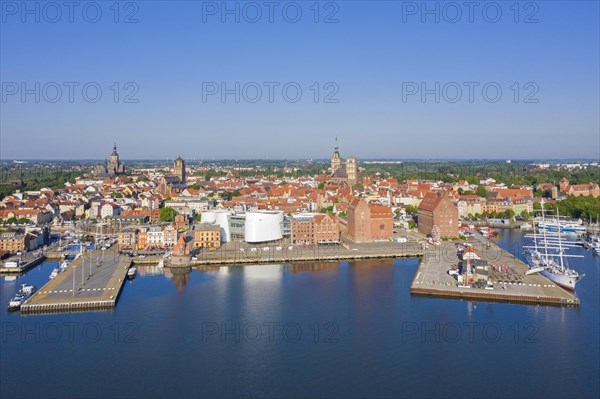 Aerial view over public aquarium Ozeaneum and three-mast barque Gorch Fock docked in harbour of the city Stralsund